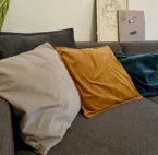 Mehrere Heizkissen mit Akku auf einem grauen Sofa